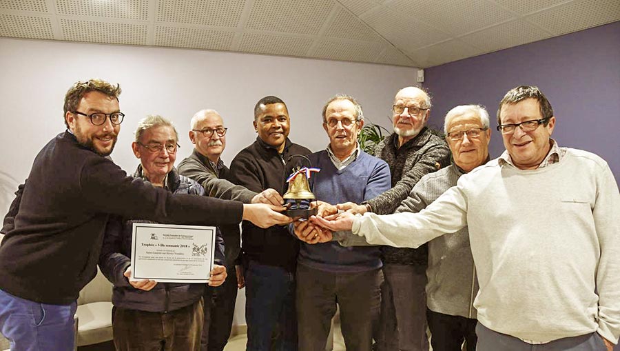 Présentation du trophée Ville sonnante par la commission mixte unissant, depuis la gauche, Vincent Laumaillé, frère Michel Legal, Roger Goupille, père Paulin Ramanandraibe (recteur de la basilique), Guy-Marie Maudet (maire), Bernard Raymond, Jacky Foulonneau et Benoît Brebion.

-Photo:Ouest France